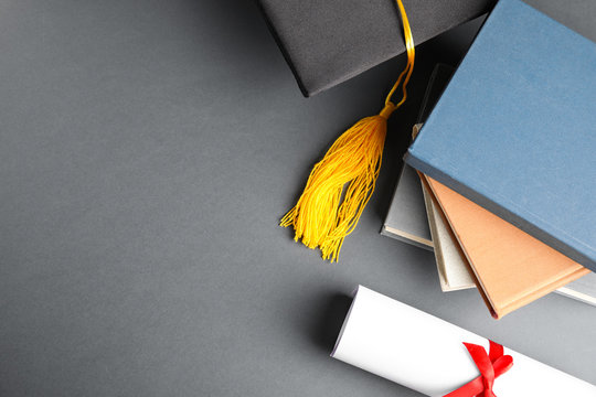 Flat lay composition with graduation hat and student's diploma on grey background, space for text