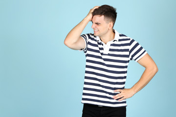 Young angry man on blue background