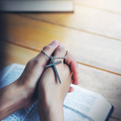 Cross on praying hand of Women faith jesus promise Pray for god  and holy bible on table