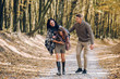 © Олег Кошевський - Beautiful young family walking in the autumn forest. Family walking in an autumn park with fallen fall leaves. Warm autumn