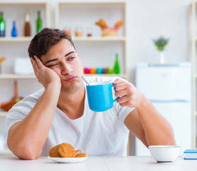 Canvas Print - Man falling asleep during his breakfast after overtime work