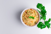 Delicious Homemade Vegetarian Couscous With Dates, Raisins, Parsley, Tomato, Lemon And Olive Oil In A White Bowl On White Background, Traditional Moroccan And Arabic Salad Tabbouleh