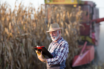 Canvas Print - Farmer in front of combine harvester