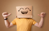 Fototapeta  - Funny man wearing cardboard box on his head with smiley face