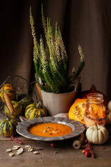 Wall Mural - Pumpkin creamy soup in ceramic plate on wooden table.