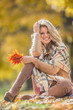 © weyo - Attractive young woman with sensual smile sitting in autumn park