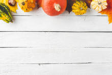 Autumn Composition With Frame Made Of Colourful Leaves And Pumpkins On White Wooden Background. Top View