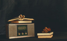Heart-shaped Books Placed On Retro Radio Receivers With Dried Flowers On Them.