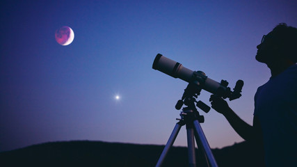 Wall Mural - astronomer with a telescope watching at the stars and moon. my astronomy work.