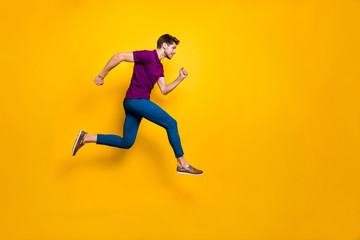 Poster - Full length body size side profile photo of fast quick handsome man wearing blue pants trousers footwear running jumping to empty space isolated over vivid color background