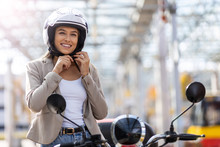 Woman On Scooter Tightens Helmet