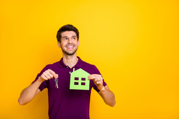 Sticker - Portrait of his he nice attractive cheerful cheery dreamy guy holding in hands keys and house figure isolated over bright vivid shine vibrant yellow color background