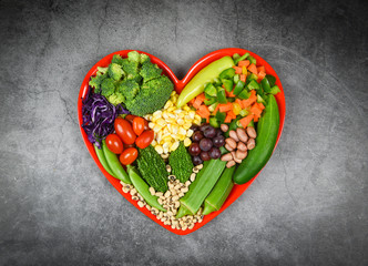 Wall Mural - Healthy food selection clean eating for heart life cholesterol diet health concept Fresh salad fruit and green vegetables mixed various beans nuts grain on red heart plate for healthy food vegan cook