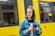 Girl with headphones listening to music waiting for the streetcar