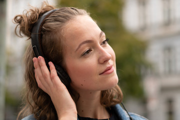 Girl with headphones listening to music walking in the downtown