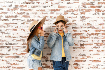 Wall Mural - Cute fashionable children against brick wall