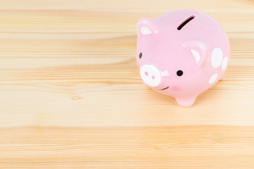 Piggy bank on wooden desk background, saving concept