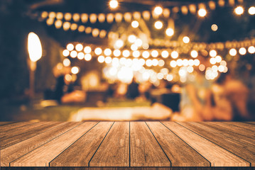 Wall Mural - wooden table in front of abstract blurred restaurant lights background