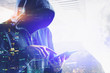 © ImageFlow - Unrecognizable hacker with tablet in city