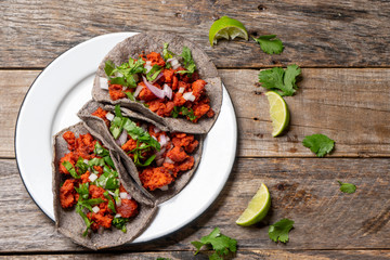 Mexican chorizo tacos with blue corn tortillas on wooden background