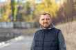 © A Stock Studio - Portrait of a middle-aged man with a beard against the backdrop of an autumn city street.