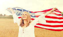 Country, Patriotism, Independence Day And People Concept - Happy Smiling Young Woman In White Dress With National American Flag On Cereal Field