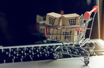 shopping online. cardboard box with a shopping cart logo in a trolley on a laptop keyboard. shopping