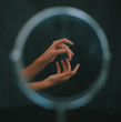© Martina - Two gesturing hands reflected in circular mirror