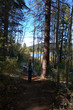 © ronm - Lady on a mountain trail along a lake using her cell phone for photos in early autumn.