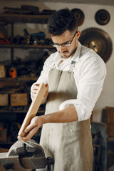 Wall Mural - Man working with a wood. Carpenter in a white shirt