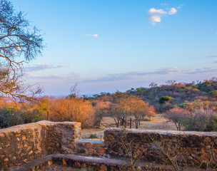 Landscape view from an old stone verandah overlooking a valley with bushy hills and a clear blue sky image with copy space in horizontal format