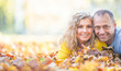 © weyo - Happy senior couple lying in autumn maple leaves