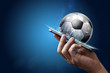 Smartphone in hand with a 3D soccer ball on a blue background. Bets, sports betting, bookmaker. Mixed media