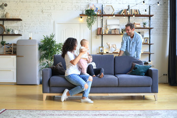 Wall Mural - Young beautiful happy family relaxing at home