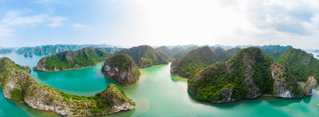 Aerial view of Ha Long Bay Cat Ba island, unique limestone rock islands and karst formation peaks in the sea, famous tourism destination in Vietnam. Scenic blue sky.