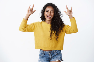 Lively charismatic african american curly-haired girl having fun, enjoy party, raise hands up rock-n-roll, heavy metal gesture, laughing happily sharing positive feelings, celebrate halloween