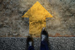 © blacksalmon - Start and Challenge Concept. a Business Man on Formal Shoes Steps to Follow a Yellow Arrow, Get Ready to Moving Forward or take a Chance to Success. Top View