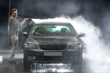 Fototapeta  - Car close-up. Car wash. Manual car wash with pressurized water in car wash outside. 