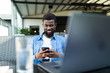 © F8  \ Suport Ukraine - Young Afro American man sitting in cafe and use cell phone.