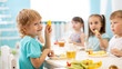 Leinwandbild Motiv children eating healthy food in kindergarten or daycare