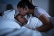 Mother Kissing Her Sleeping Daughter On Bed