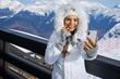 © ZoomTeam - woman with her smartphone camera shot selfie on the top of mountain under blue sky with sunlight at sunny winter day, travel vacation, mountains background.