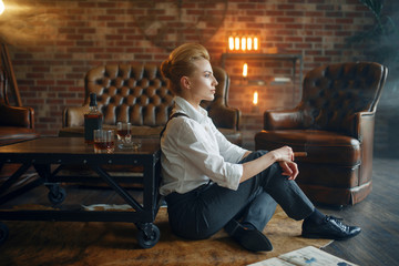 Wall Mural - Woman sitting on the floor with whiskey and cigar