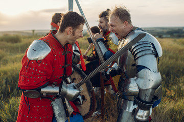 Medieval knights fight with sword and axe