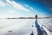 Man Walking In Snow Footprints