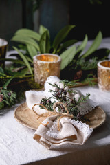 Wall Mural - Christmas or New year table setting with empty ceramic plates, napkins, Christmas thuja wreath and burning candles on white tablecloth. Holiday mood