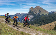 Three Happy Senior Adults, Riding Their Mountain Bikes In The Autumnal Atmosphere Of The Bregenz Wald Mountains Near Mellau, Vorarlberg, Austria