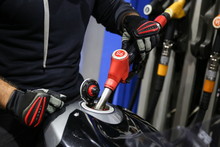 Biker Hand Holds A Fuel Filling Gun In A Motorcycle Tank On The Gas Station