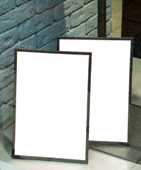 two empty, white signs behind the glass of the store, against the background of a painted brick wall