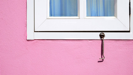 Wall Mural - Sunlight on surface of window hook and part of white window on pink cement wall background, home exterior concept